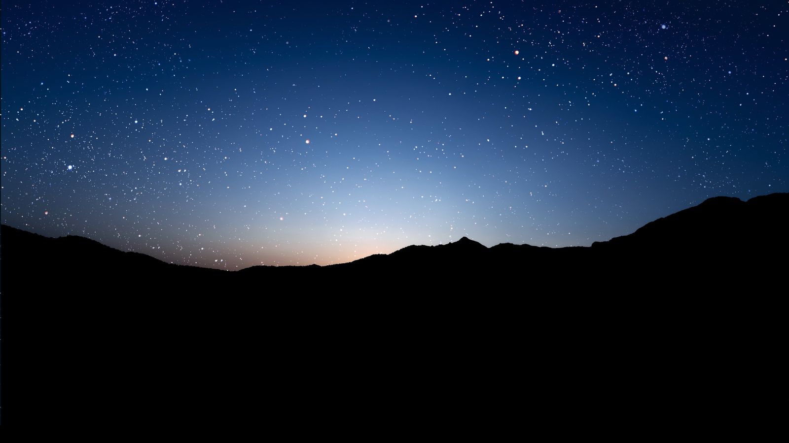 Céu estrelado sobre a silhueta de montanhas